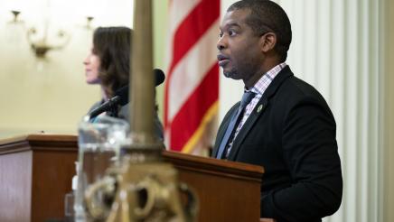 At podium presiding over ceremony